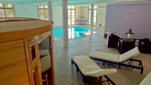 - un salon avec une piscine, une table et des chaises dans l'établissement Château Ferrassières, à Ferrassières