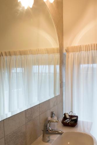 a bathroom with a sink and a mirror at Colleverde Country House & SPA Urbino in Urbino