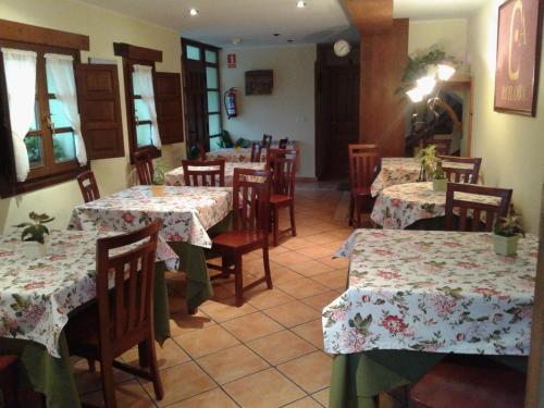 Camango的住宿－羅伊洛瓦村莊旅館，餐厅设有桌椅,并种有鲜花