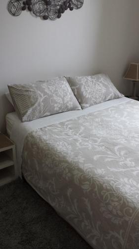 un letto con lenzuola e cuscini bianchi in una camera da letto di Freo for Two a Fremantle