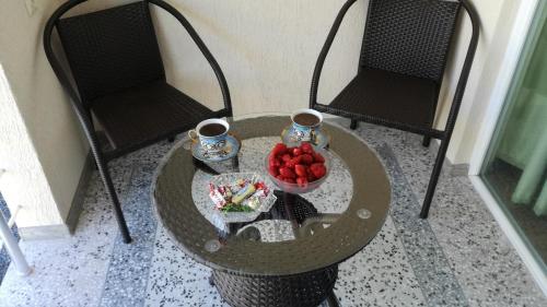 a table with a bowl of fruit and two chairs at Luka & Eka in K'obulet'i