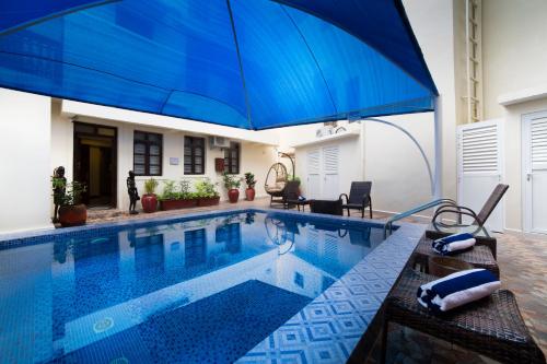 a blue pool with a blue umbrella on top of it at Spice Palace Hotel in Zanzibar City