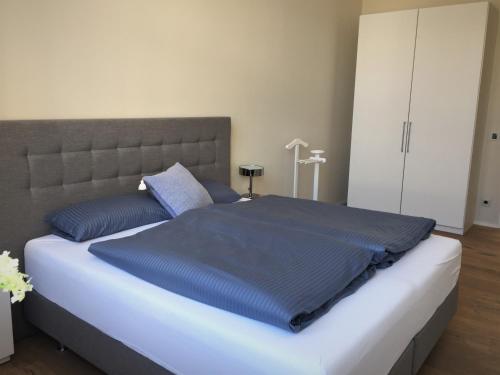 ein Schlafzimmer mit einem großen Bett mit blauen Kissen in der Unterkunft Anker Guest House in Bielefeld