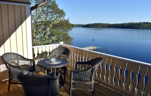 a table and chairs on a balcony with a view of a lake at Håveruds hotell och konferens in Håverud