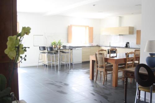 a kitchen with a table and chairs and a kitchen with white cabinets at Casa Moderna Proxima da Praia in Santa Catarina