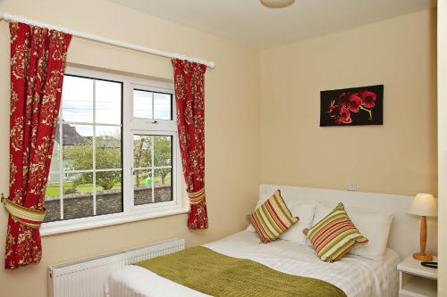 a bedroom with a bed and a window at Ashville House in Killarney
