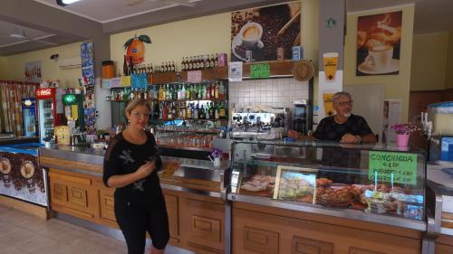 a woman standing in front of a counter in a restaurant at Kamemi Village & Camping in Ribera