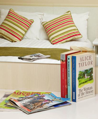 a bed with books and magazines on top of it at Ashville House in Killarney