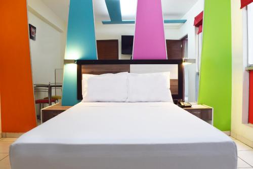 Cama en habitación con paredes coloridas en Hotel Colors Canada, en Lima