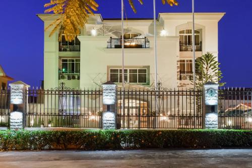 a white building with a fence in front of it at BON Hotel Abuja in Abuja