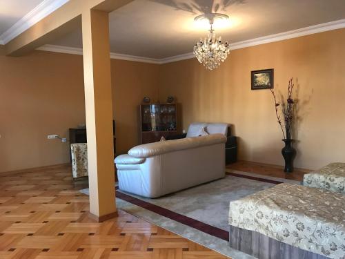 a living room with a couch and a chandelier at Guest House kartvelishvili in Batumi