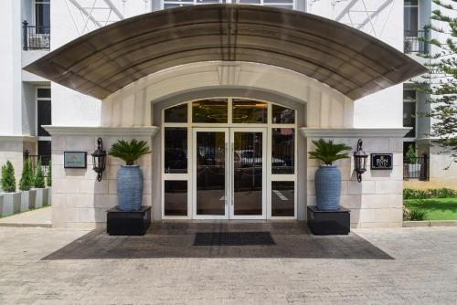 a building with two vases with palm trees in it at BON Hotel Abuja in Abuja