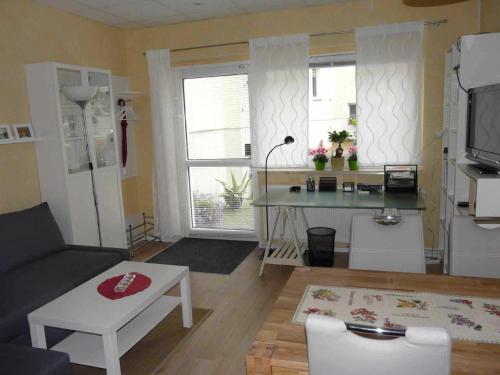 ルターシュタット・ヴィッテンベルクにあるFerienwohnung Winterのリビングルーム(ソファ、テーブル付)、キッチンが備わります。