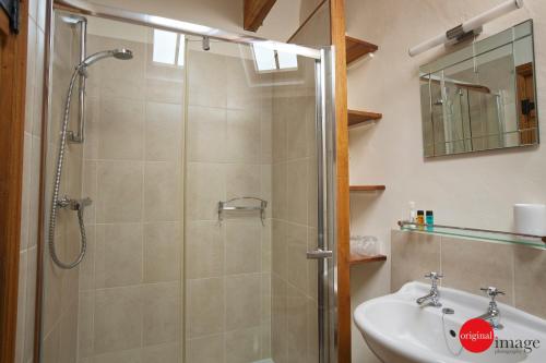 a bathroom with a shower and a sink at Jacks Cottage in Totnes