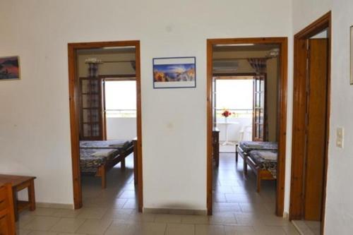 a room with two doors and a hallway with beds at Irene Apartments in Acharavi