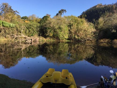 a yellow boat on a river with a view of the water at The Riverdeck Accommodation and Backpackers in Knysna