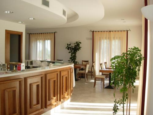 a kitchen with wooden cabinets and a dining room at Colleverde Country House & SPA Urbino in Urbino