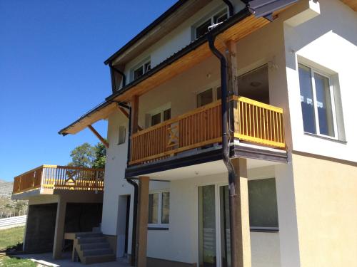 ein Haus mit zwei Balkonen an der Seite in der Unterkunft Utopia Mountain resort Bjelasnica in Bjelašnica