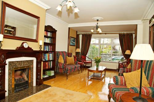 a living room with a fireplace and a mirror at Ashville House in Killarney