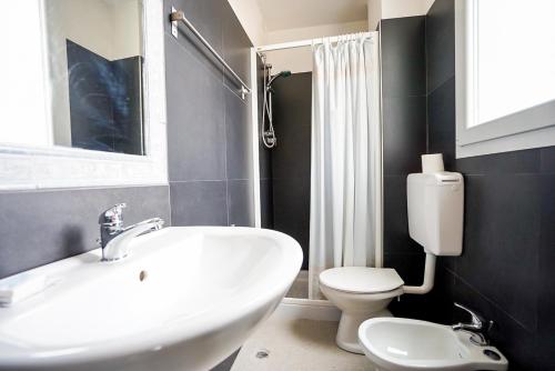 a bathroom with a white sink and a toilet at Hotel Elba in Rimini