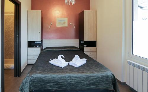 a bedroom with a bed with white shoes on it at Villa Le Logge in Ventimiglia