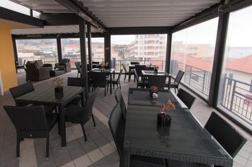 a restaurant with tables and chairs and large windows at Villa Le Logge in Ventimiglia