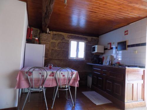 a kitchen with a table and chairs in a room at Casa da Venda in Covide