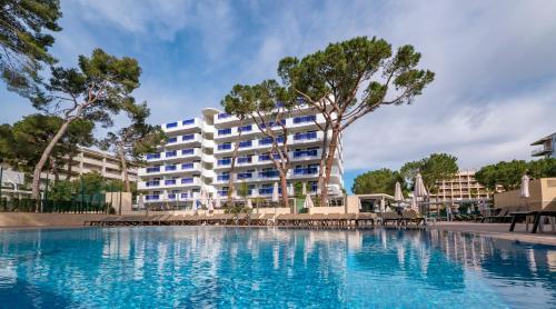 un hotel con piscina frente a un edificio en Golden Port Salou & Spa en Salou