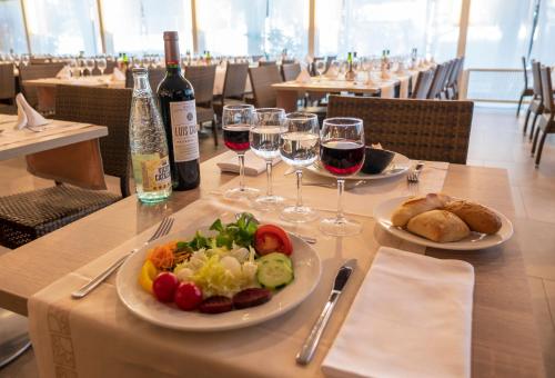 a table with two plates of food and wine glasses at Golden Port Salou & Spa in Salou
