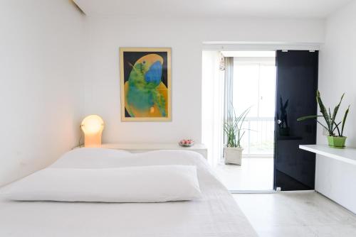 1 dormitorio blanco con 1 cama y una pintura en la pared en Moderno Apartamento com Vista Mar | V 90/102, en Río de Janeiro