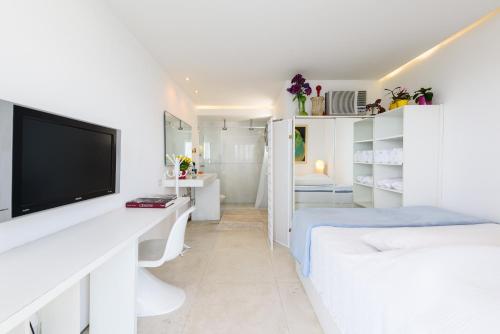 Habitación blanca con cama y TV en Moderno Apartamento com Vista Mar | V 90/102, en Río de Janeiro