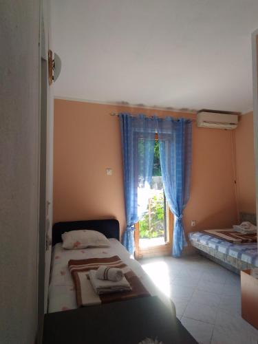 a small bedroom with a bed and a window at Apartment Angelina in Risan