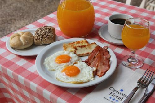 a breakfast plate of eggs bacon and bread and orange juice at Centrum Hotel - City Center in Nicosia