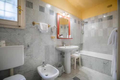 a bathroom with a sink and a toilet and a tub at Hotel Torre Guelfa Palazzo Acciaiuoli in Florence