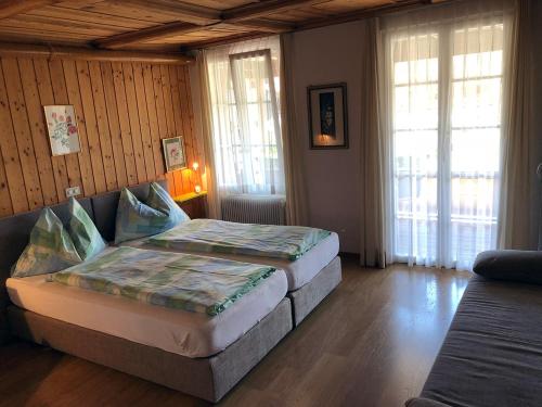 a bedroom with two beds in a room with windows at Post Hardermannli in Interlaken