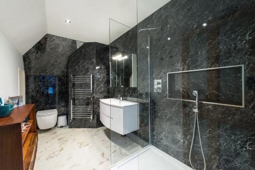 a bathroom with a glass shower and a sink at 3 Eskbank Terrace in Dalkeith