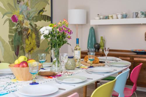 a table with plates and glasses and flowers on it at Eskbank Villa near Edinburgh in Dalkeith