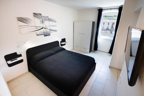 a bedroom with a black bed in a room at The House On The River in Bosa
