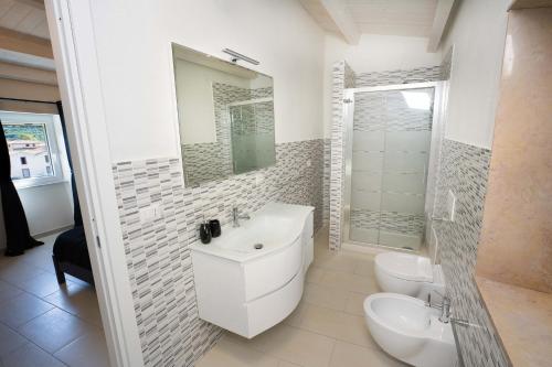 a white bathroom with a sink and a toilet at The House On The River in Bosa