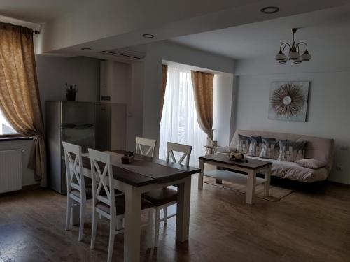 a living room with a table and chairs and a couch at apartament 2 camere ultracentral in Râmnicu Vâlcea