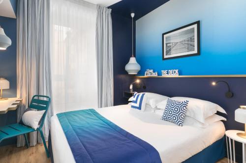 Dormitorio azul con cama y pared azul en The Deck Hotel by Happyculture, en Niza