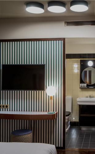 a room with a bed and a bathroom with a sink at Hôtel du Rond-point des Champs-Élysées - Esprit de France in Paris