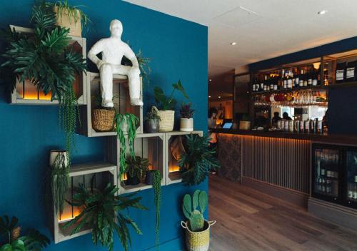 a room with plants on the wall and a bar at The Corner London City in London