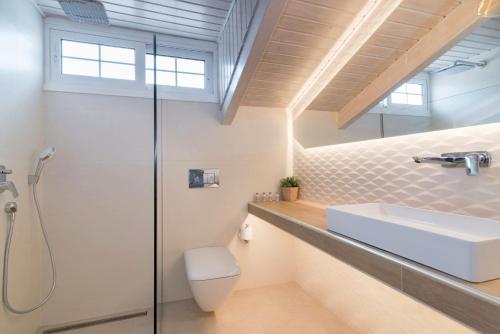 a bathroom with a sink and a shower at Edelweiss Hotel in Argasi