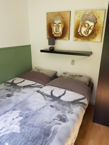 1 dormitorio con 2 camas con ciervo y máscara en Bungalow Hartje Veluwe, en Otterlo