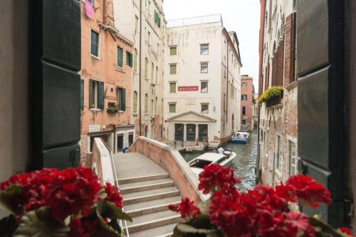 威尼斯的住宿－Ca' Milion，享有运河美景,窗户上装有红色鲜花