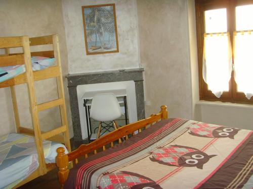ein Schlafzimmer mit einem Bett und einem Kamin in der Unterkunft Le Bravard in Jumeaux