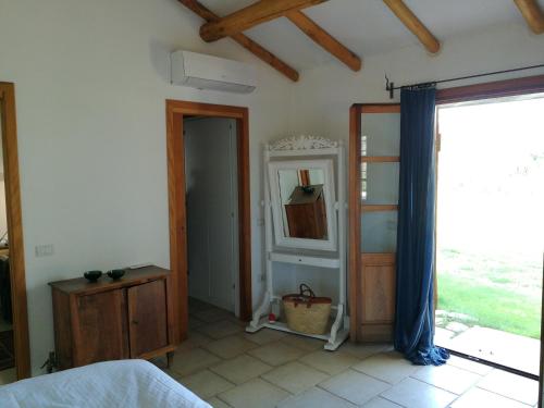 a bedroom with a bed and a mirror and a window at Sa Rezzetta in Golfo Aranci