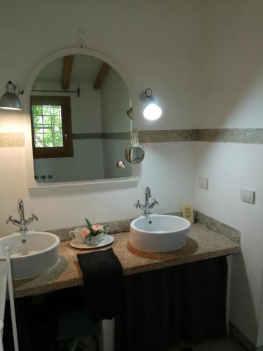 a bathroom with two sinks and a large mirror at Sa Rezzetta in Golfo Aranci