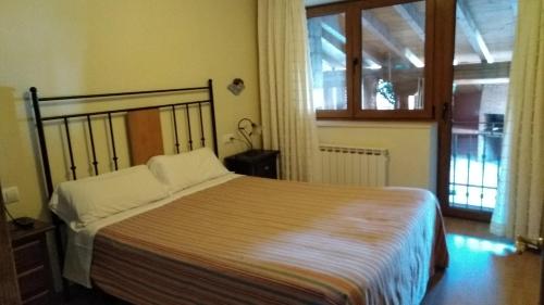 a bedroom with a bed and a large window at El Torreón I in Hoyos del Espino